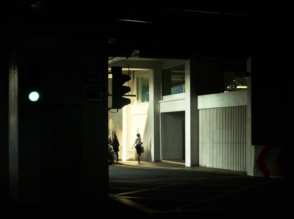 person walking beside concrete wall