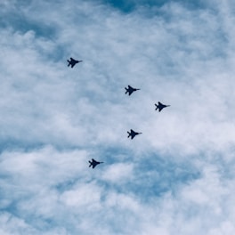 Swarm of UAVs coordinating a precise formation over critical infrastructure at twilight.