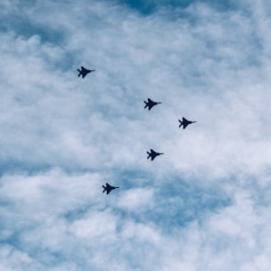Swarm of UAVs coordinating a precise formation over critical infrastructure at twilight.