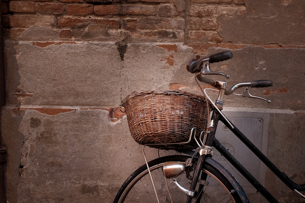Schwarzes und graues Cruiser-Fahrrad an die Wand gelehnt