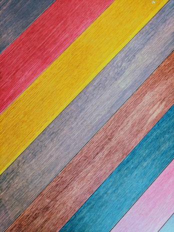 A pile of wooden planks nailed together with crooked screws, glowing with neon pink edges.