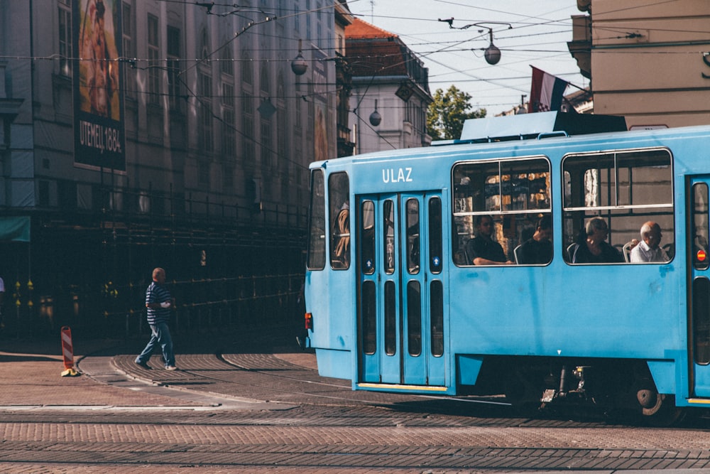 blue tram near building during daytime