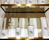 A collection of insulated bottles and glass tumblers arranged neatly against a minimalist backdrop.