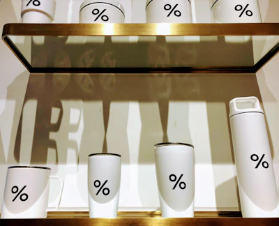 A collection of insulated bottles and glass tumblers arranged neatly against a minimalist backdrop.