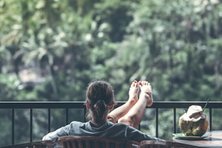 person sitting on chair in front of tree