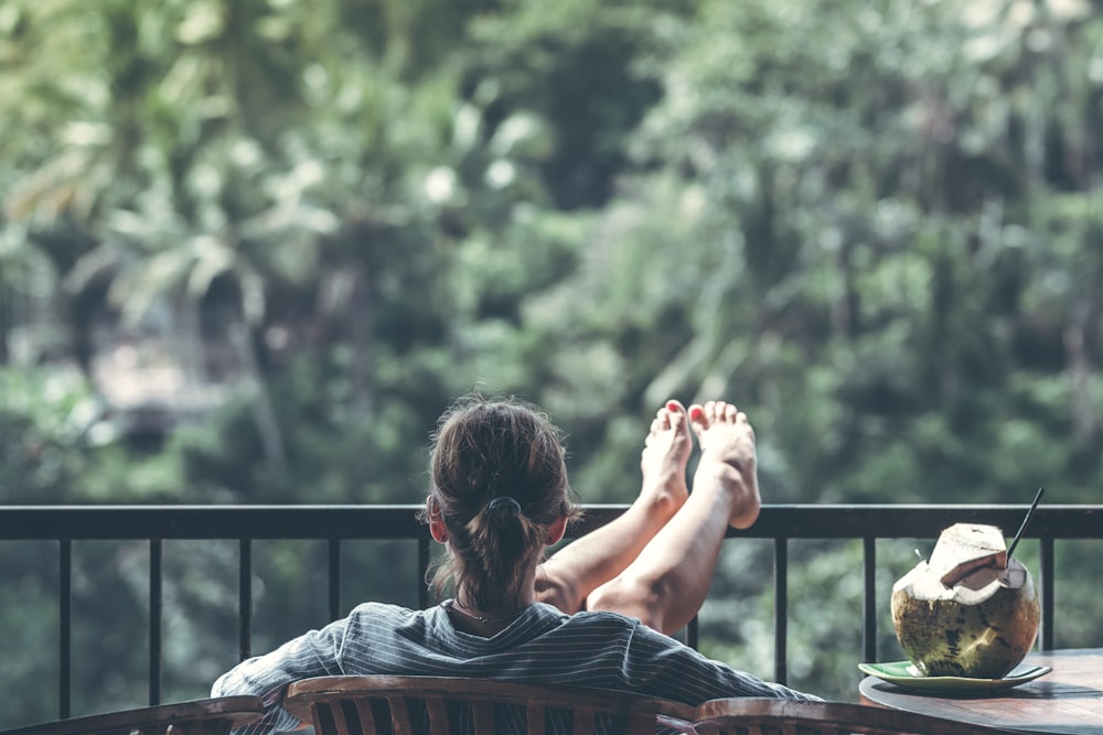 person sitting on chair in front of tree