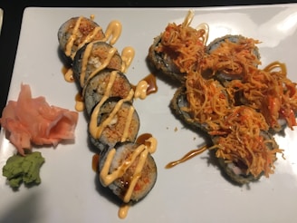 Freshly prepared sushi rolls with vibrant fillings, served with wasabi and ginger on the side.