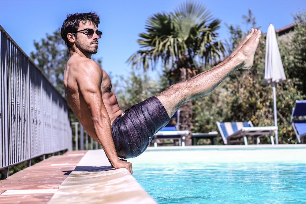 man sitting beside pool