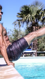 man sitting beside pool