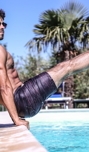 man sitting beside pool