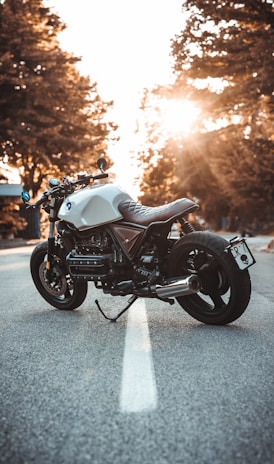 white and black BMW cruiser motorcycle in the center of road