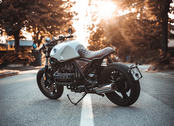 white and black BMW cruiser motorcycle in the center of road