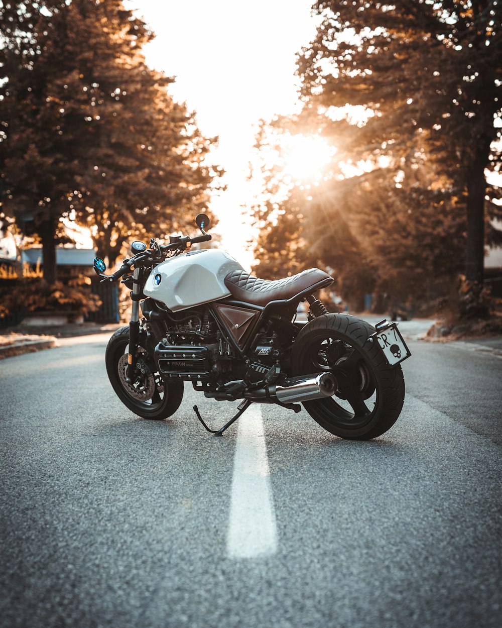 white and black BMW cruiser motorcycle in the center of road