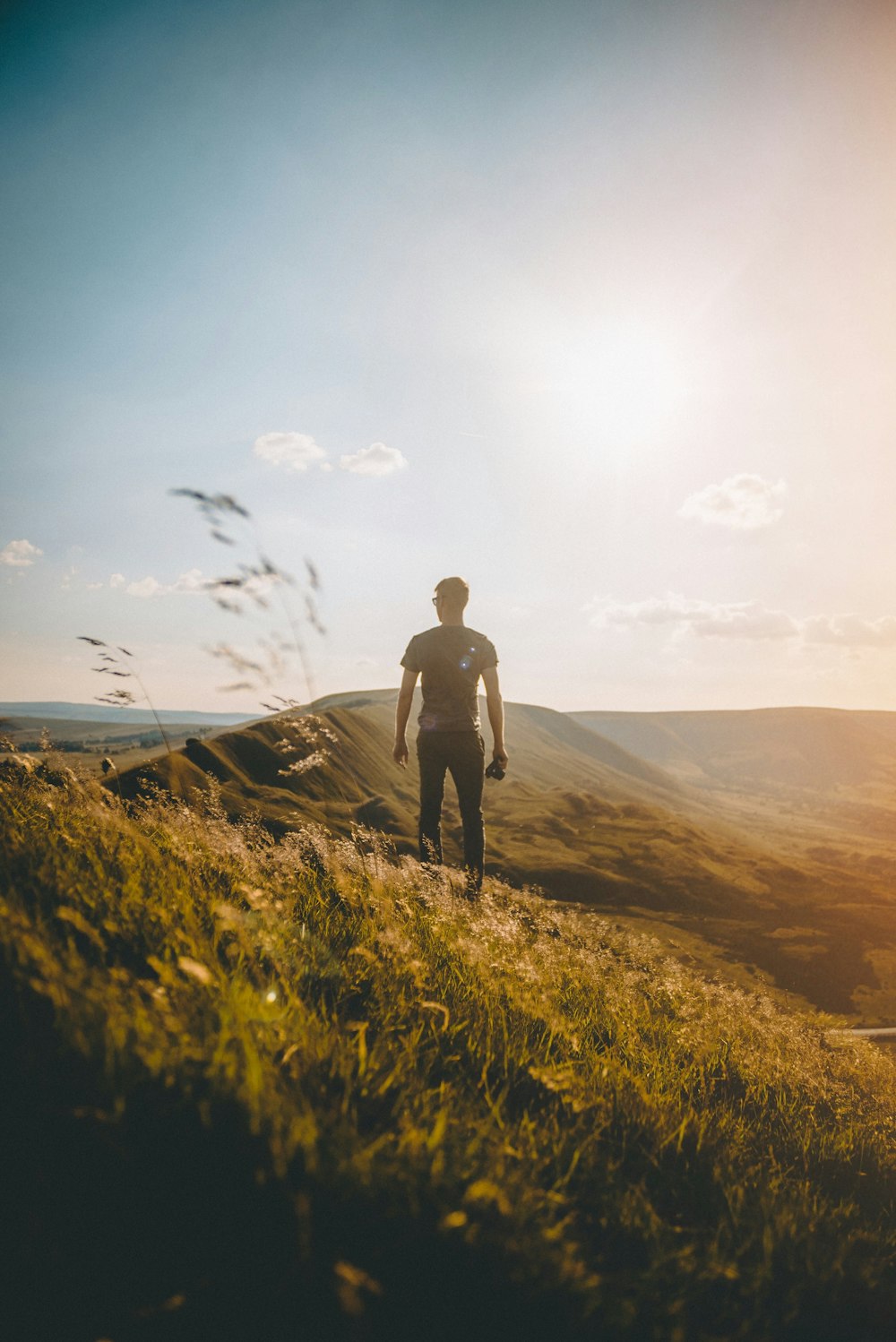 man standing on green grass under blue sky