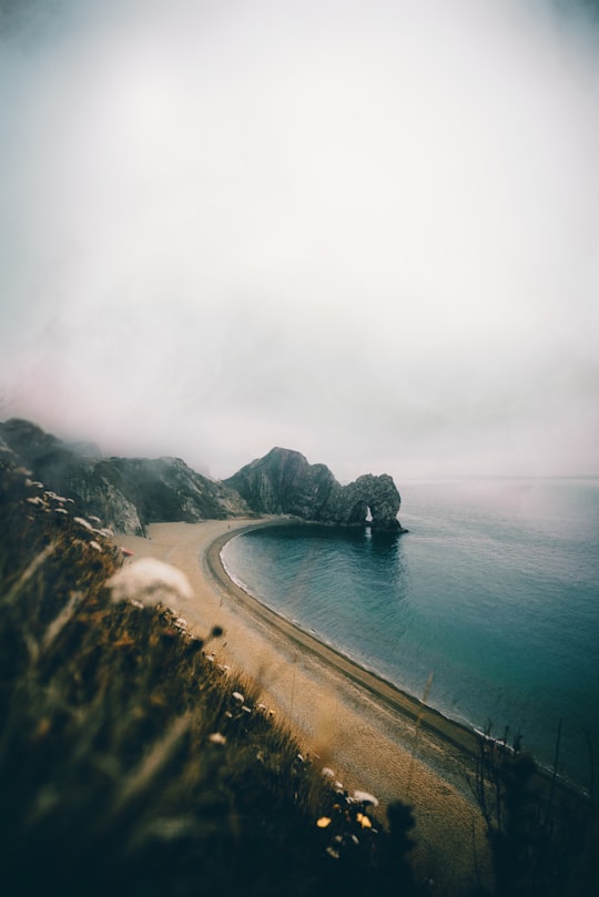 seashore under cloudy sky in Durdle Door United Kingdom