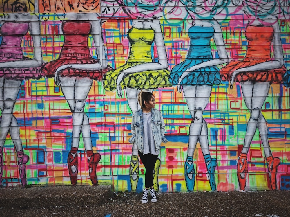 woman standing beside graffiti wall art