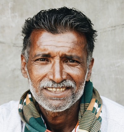 close-up photo of man in white shirt smiling while taking photo