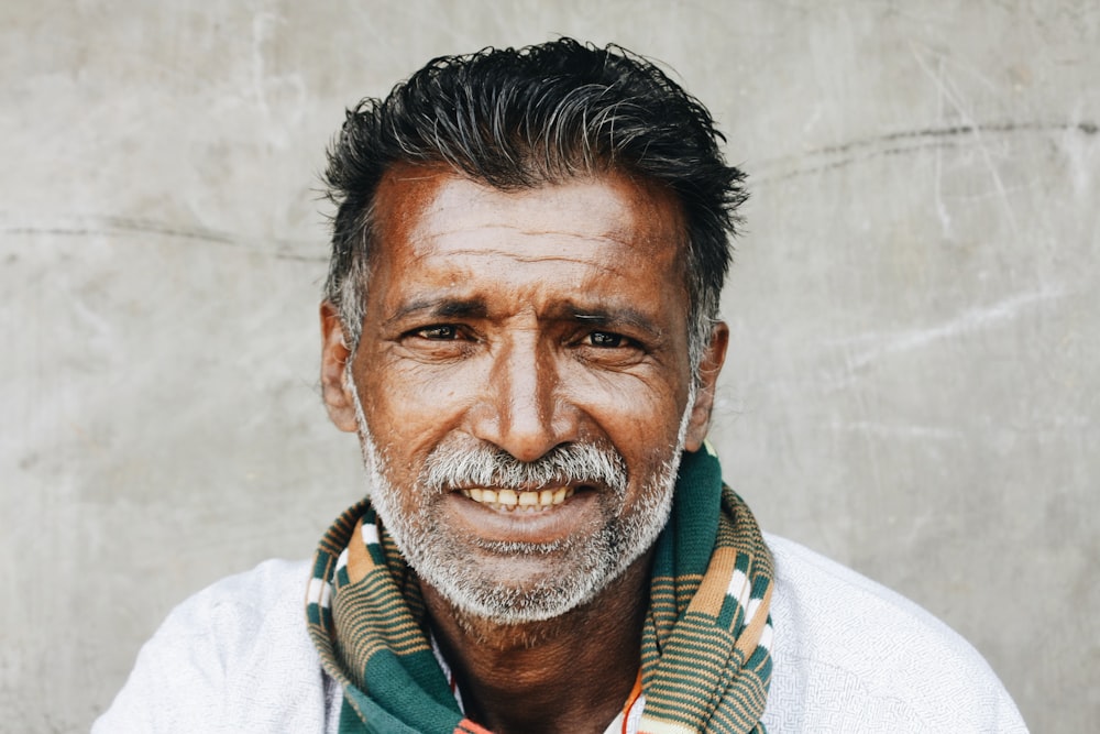 close-up photo of man in white shirt smiling while taking photo