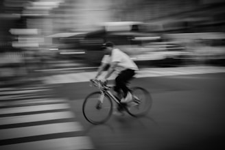 A candid shot of a person cycling through the city in Lumina Apparel activewear, capturing motion and energy.