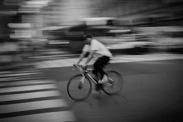 A candid shot of a person cycling through the city in Lumina Apparel activewear, capturing motion and energy.