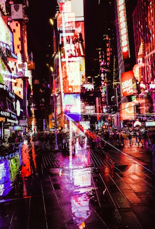 A sleek, dark-themed digital billboard glowing with neon accents in a bustling urban night scene.