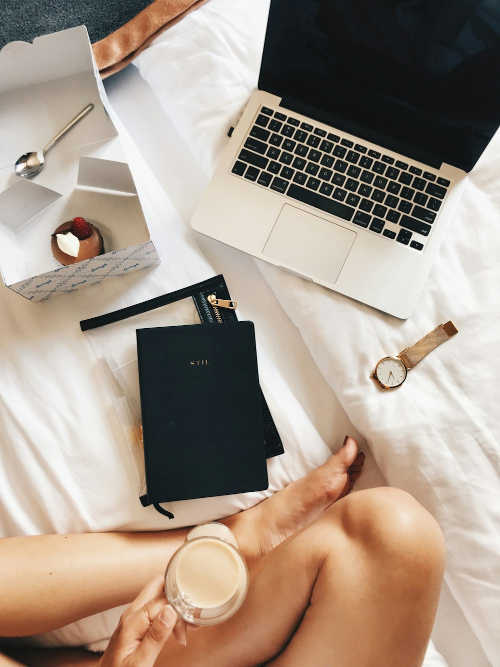 person sitting beside MacBook Pro and analog watch