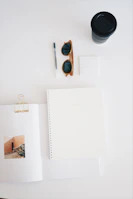 A flat lay of various study materials including notebooks, pens, and a cup of coffee on a wooden table.