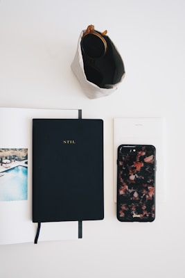 A creative flat lay featuring t-shirts alongside accessories like sunglasses and a notebook, evoking a laid-back vibe.