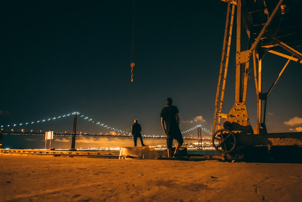 person in black t-shirt standing beside metal machine