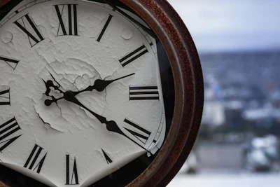A weathered clock face against a backdrop of shifting clouds, symbolizing the passage of time.