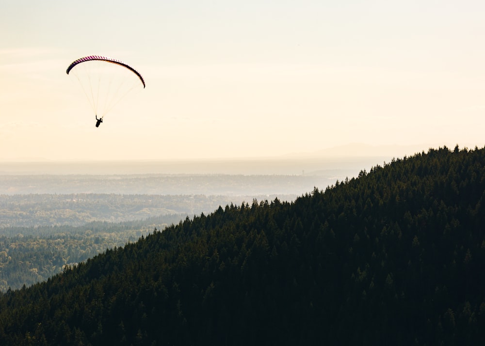 persona parapendio vicino alla montagna