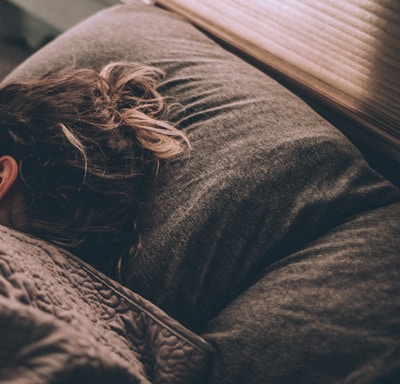 woman sleeping on bed under blankets