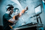 man controlling DJ controller beside man with microphone