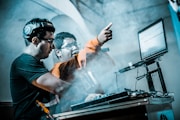 man controlling DJ controller beside man with microphone