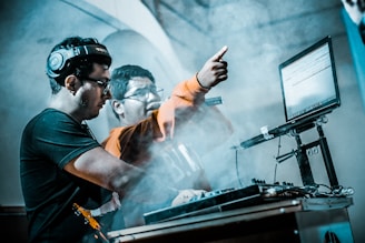 man controlling DJ controller beside man with microphone