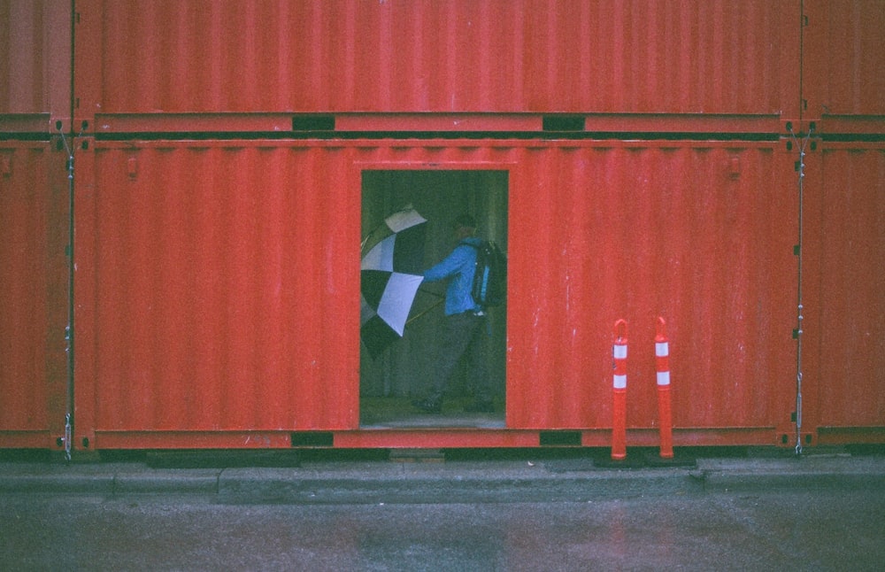 man holding umbrella inside the intermodal container