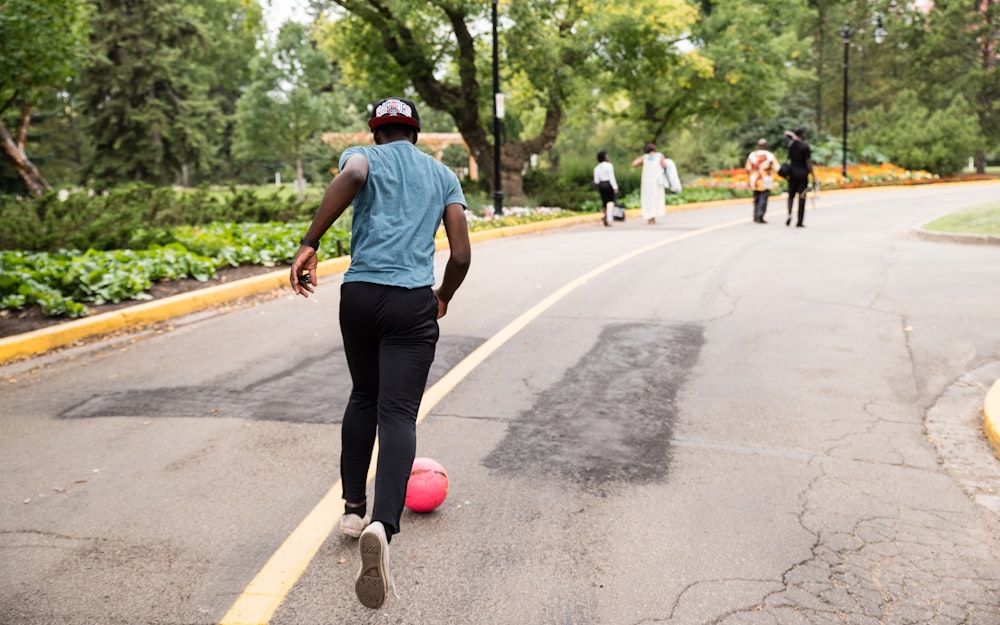 man running behind red ball