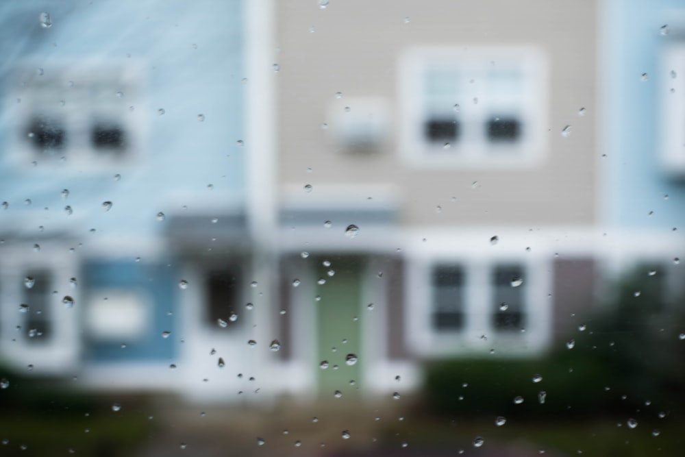 selective focus photography of rain droplets on vehicle window
