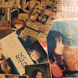 A collage of various posters and flyers, some featuring portraits of people in different poses and expressions, likely from movies or promotional events. The text on the materials appears to be in Japanese, with colorful and diverse visuals.