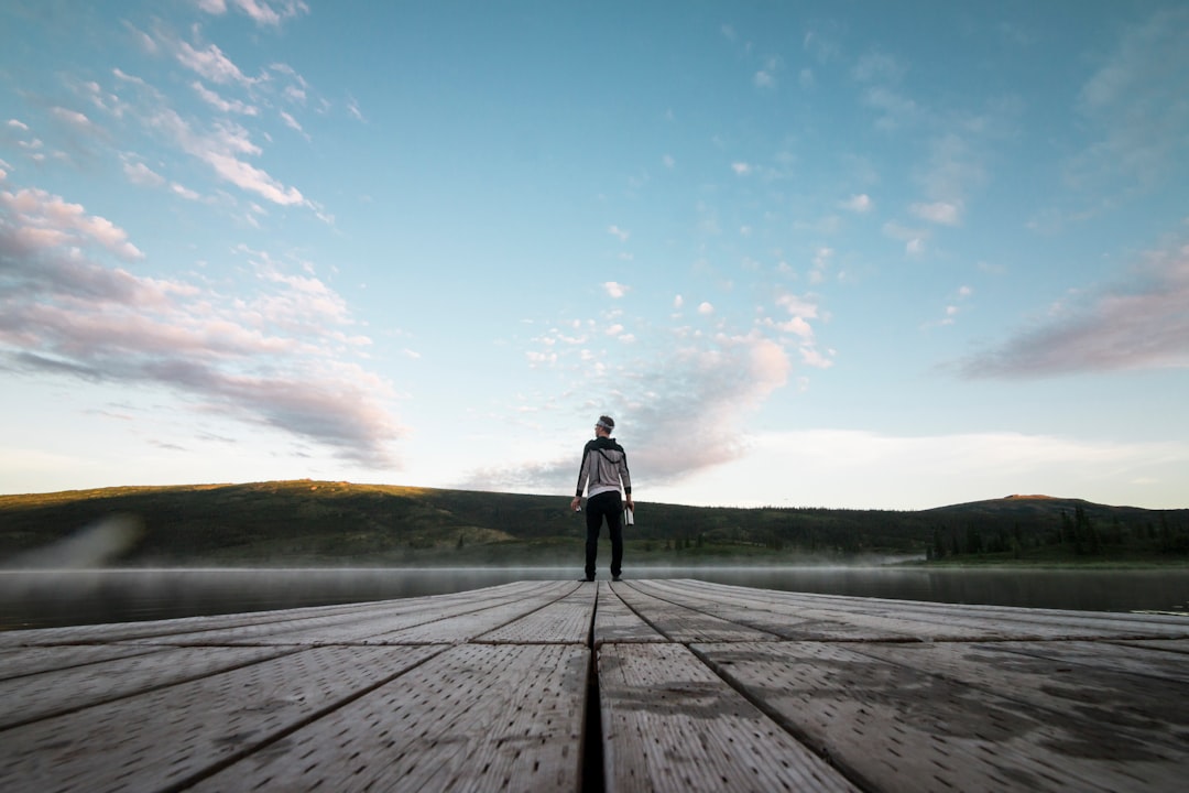 man standing on gray surface near mountain peak