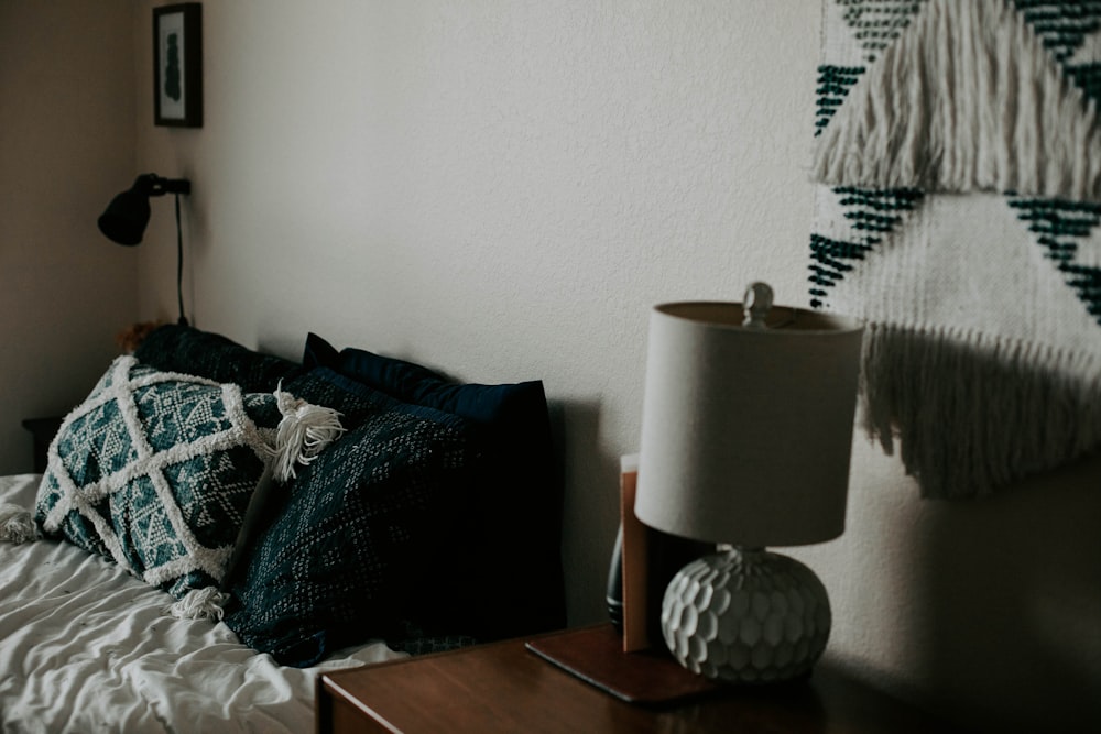 white table lamp on wooden side table