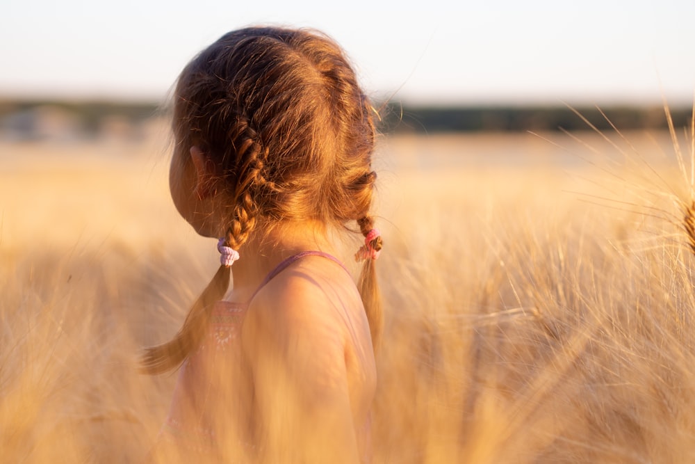 Ragazza che indossa una canotta rosa su una pianta marrone durante il giorno