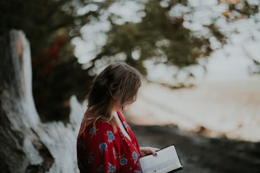 woman holding book on beach