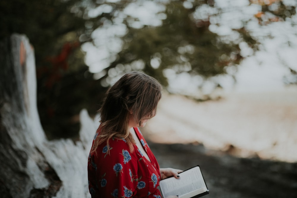 Mujer sosteniendo un libro en la playa