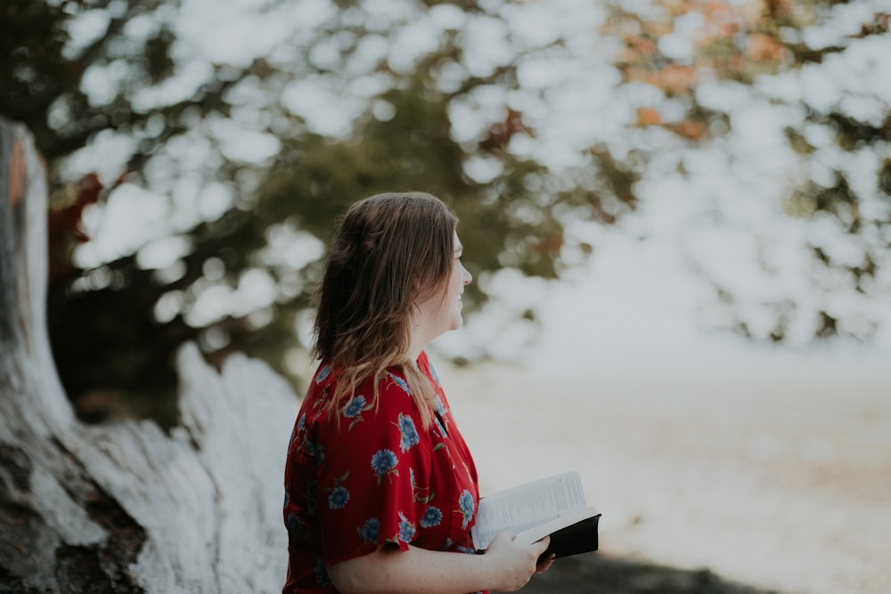 woman holding book outdoors