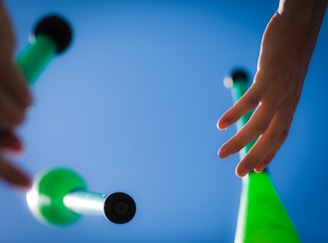 Colorful juggling clubs arranged in a fan shape on a wooden floor.