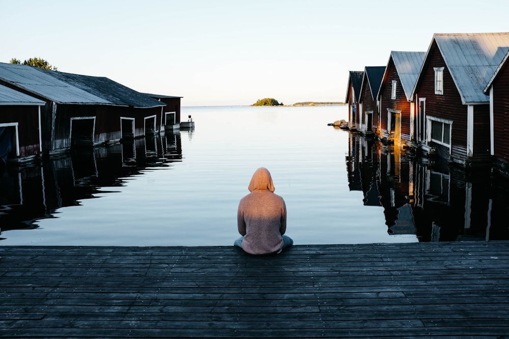 person sitting beside body of water