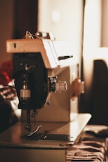 closeup photo of gray and black electric sewing machine