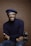 smiling man wearing black turtleneck shirt holding camrea
