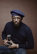 selective focus photo of man holding camera with flash